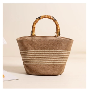 Detail of hand-woven straw bag with bamboo handle and brown striped texture pattern