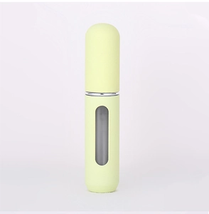 Close-up of matte yellow 5ml perfume atomizer bottle with clear liquid level window
