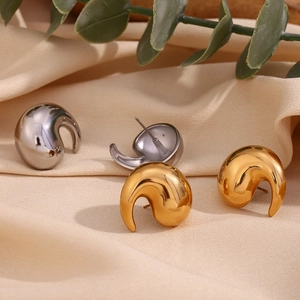Detailed macro view of 18K gold and silver water drop earrings on elegant beige silk