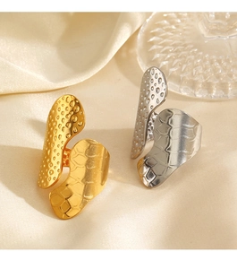 Detail of gold and silver chunky textured rings on silk background with soft lighting