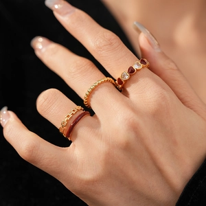 Detail of vintage gold stackable rings with red heart pattern and zircon inlay