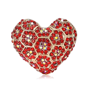 Broche cœur élégante en alliage doré avec strass rouges et irisés sur fond blanc