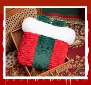 Plush Christmas gift bag inside a vintage woven suitcase on a red paisley carpet