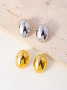 Macro detail of polished oval titanium steel earrings in silver and gold finishes