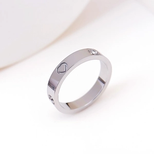 Detail of silver titanium ring featuring a hollow heart and two small crystals