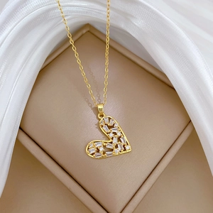 Macro shot of gold hollow heart pendant with sparkling crystals on fine O-chain
