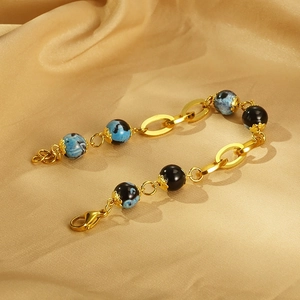 Detail of vintage gold chain bracelet with blue marble resin beads and lobster clasp