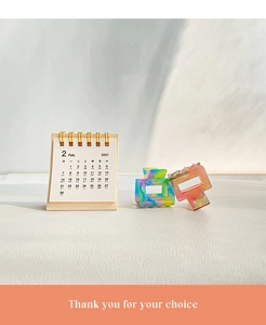 Detail of two acetate claw clips with colorful marble texture on a white surface