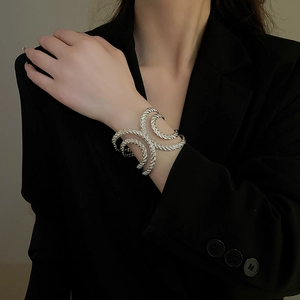 Macro shot of silver twisted rope texture on an irregular open metal cuff bracelet