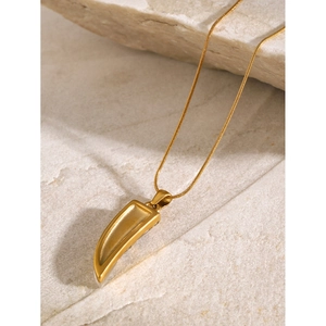 Detail of 18k gold plated cat eye stone pendant on a chic horn shaped necklace