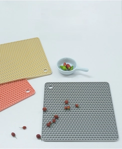 Detail of square honeycomb silicone placemats in beige, pink and grey with hanging holes