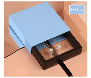 Detail of sky blue PE film floating display box with golden drop earrings inside