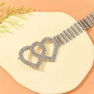 Elegant silver belly dance waist chain with double heart rhinestones on a beige mat
