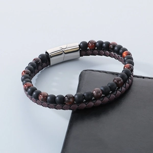 Macro detail of double-layer men's bracelet with tiger eye beads and braided brown leather