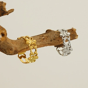 Artistic display of gold and silver hollow stainless steel rings on a wooden branch