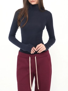 Detailed view of dark blue slim fit turtleneck sweater fabric and hourglass waist fit