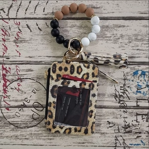 Detailed macro view of leopard print card holder with silicone beaded wristlet and gold hardware