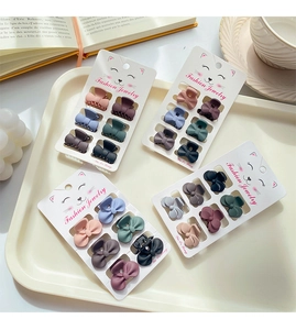 Detail of matte hair clips in Morandi colors on jewelry cards with lifestyle props
