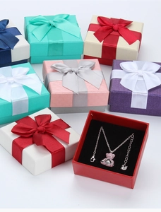 Detail of square jewelry gift boxes with bows and crystal bear necklaces in various colors