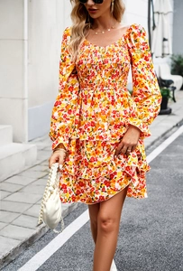 Detail of square neckline with smocked chest and orange floral pattern on mini dress