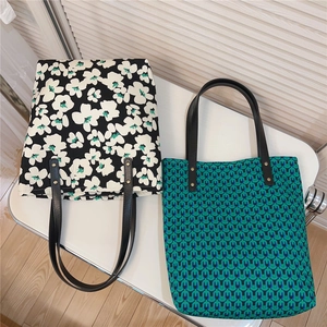 Close-up of vintage green print and floral pattern cotton canvas tote bags on a desk