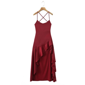 Detail of burgundy satin dress showing crisscross straps and asymmetric ruffled hemline