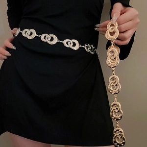 Close-up of golden belt chain with rhinestone double rings and adjustable clasp link