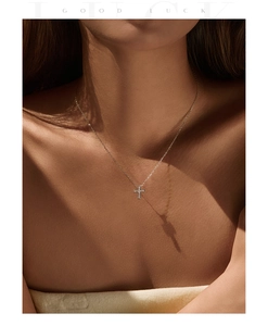 Close-up of S925 sterling silver cross necklace on model with artistic shadows