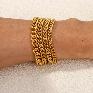 Set of four gold-plated Cuban link bracelets in varying widths worn on a wrist
