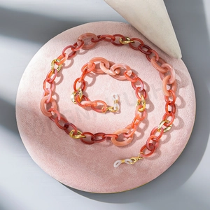 Detailed macro view of colorful acrylic eyewear chain links with golden metal rings
