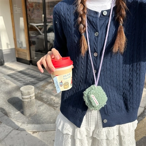 Mini custodia per cuffie in peluche verde menta con cordino viola indossata a tracolla