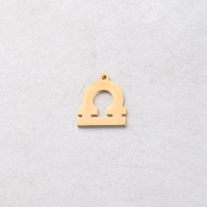 Detailed view of a 15mm gold Libra constellation charm with polished mirror finish