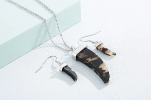 Détail macro d'un ensemble collier et boucles d'oreilles en forme de corne argentée