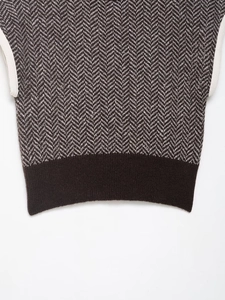 Detail of herringbone knit pattern with contrast white piping and brown ribbed hem