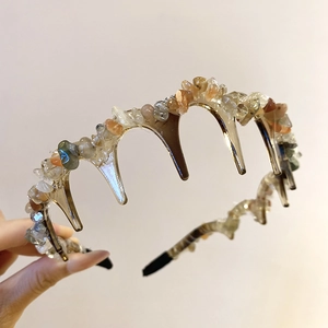 Detail of amber acrylic headband with irregular stones and functional teeth for hair grip