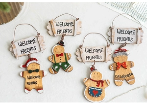 Detailed view of Christmas wooden gingerbread man welcome signs with festive textile accents