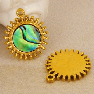 Detail view of gold sun pendant with turquoise shell inlay and matte back texture