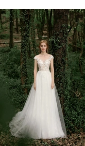 Detailed lace floral embroidery on illusion neckline of a white tulle forest bridal gown