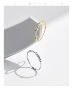 Detailed view of gold and silver twisted rope rings set with sparkling clear zircons