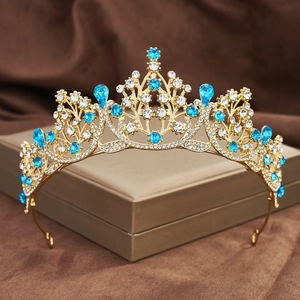 Macro shot of gold baroque crown with blue crystal teardrops on a jewelry box