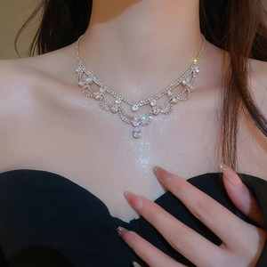 Elegante collana dorata a doppio strato con pendente in cristallo a goccia su una modella