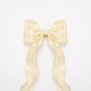 Elegant white satin ribbon bow hair clip with long streamers and iridescent pearl finish