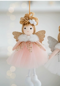 Close-up of cute Christmas angel doll with pink mesh tutu and sparkling gold wings