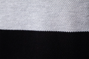 Makro-Texturdetail des schwarz-grauen Strickgewebes mit Farbeinsatz auf Herrenpullover