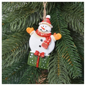 Detail view of a snowman ornament with red scarf hanging on a green Christmas tree branch