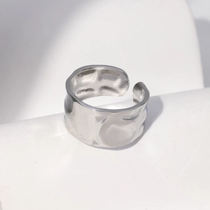 Detailed view of silver stainless steel open ring with hammered texture on white background