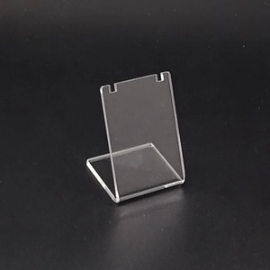 Detail of transparent L-shaped acrylic necklace stand with top slots on black background