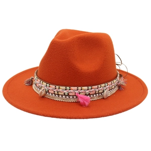 Detail of orange wool fedora with bohemian woven band, pink tassels and sea shells