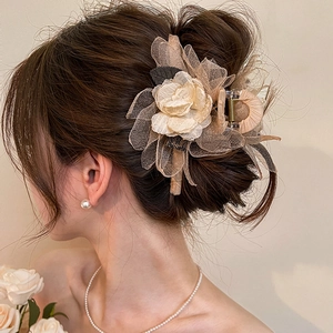 Detail of rose hair claw clip in champagne mesh showing 3D flower texture on hair