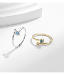 Detail of adjustable S925 silver and gold rings with blue turquoise devil eye design